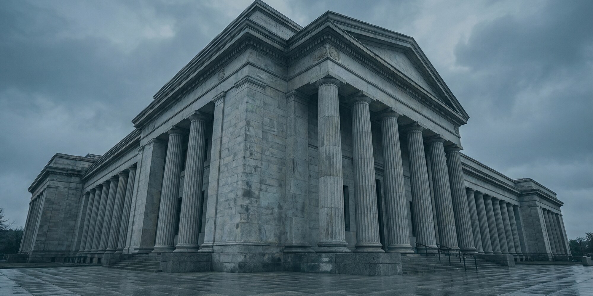 Neoclassical government banking institution building with stone columns under a dramatic overcast sky