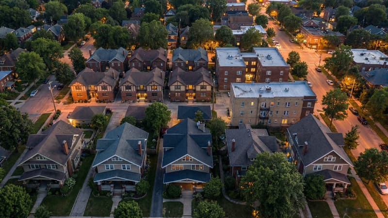 Aerial view of a diverse mixed-density American neighborhood showing single-family homes alongside duplexes, small apartment buildings, and tree-lined streets — representing the spectrum of housing types that preemption laws unlock